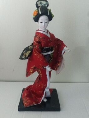 Japanese Geisha Doll in Red Kimono with Pretty Hair Pins Posing on Black Stand